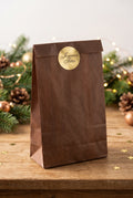 Enveloppe cadeau marron avec autocollant doré “Joyeuses Fêtes