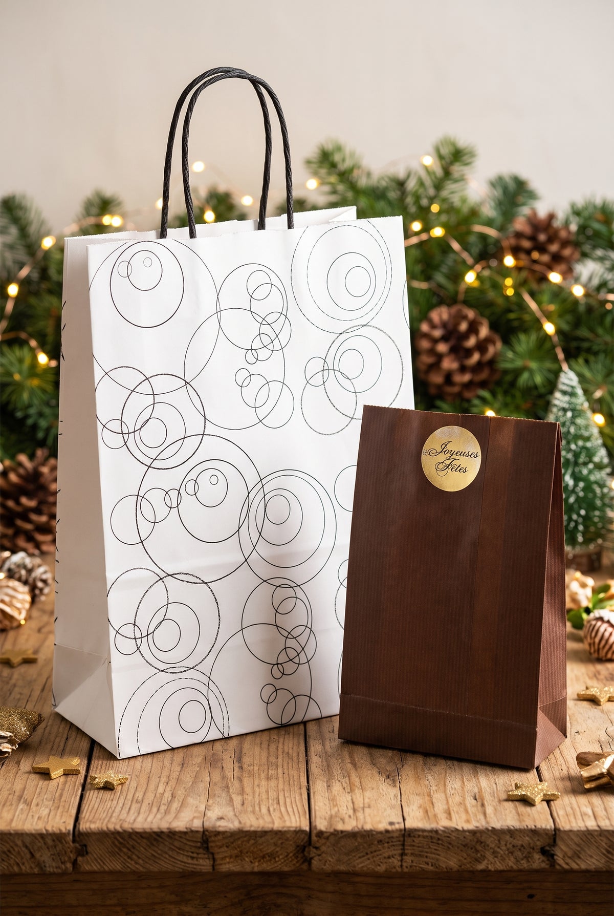 Sac cadeau blanc à motifs de cercles noirs et anses noires.